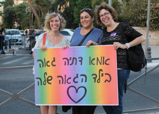 שלשוש אמהות מחזיקות שלט שעליו כתוב: "אמא דתיה גאה בילד הגאה שלה"