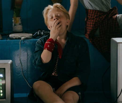 אישה מפהקת יושבת על ספסל כחול